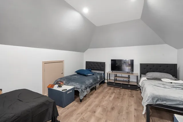 a bedroom with a bed and a tv on the dresser