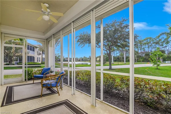 a living room with patio furniture and garden view