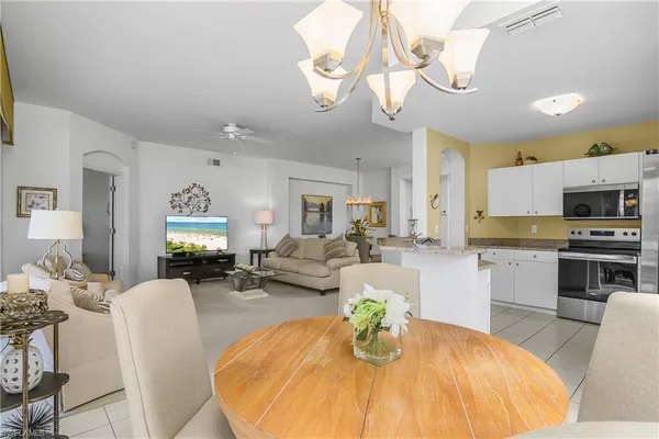 a living room with stainless steel appliances kitchen island granite countertop furniture and a fireplace