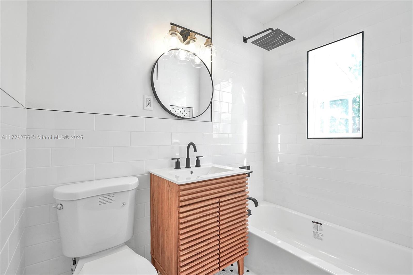 9173 Byron Avenue Surfside, FL 33154 - Photo 11 of 25 a bathroom with a sink a toilet and a mirror