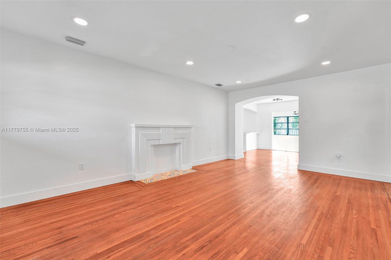 9173 Byron Avenue Surfside, FL 33154 - Photo 13 of 25 a view of empty room with wooden floor and fireplace