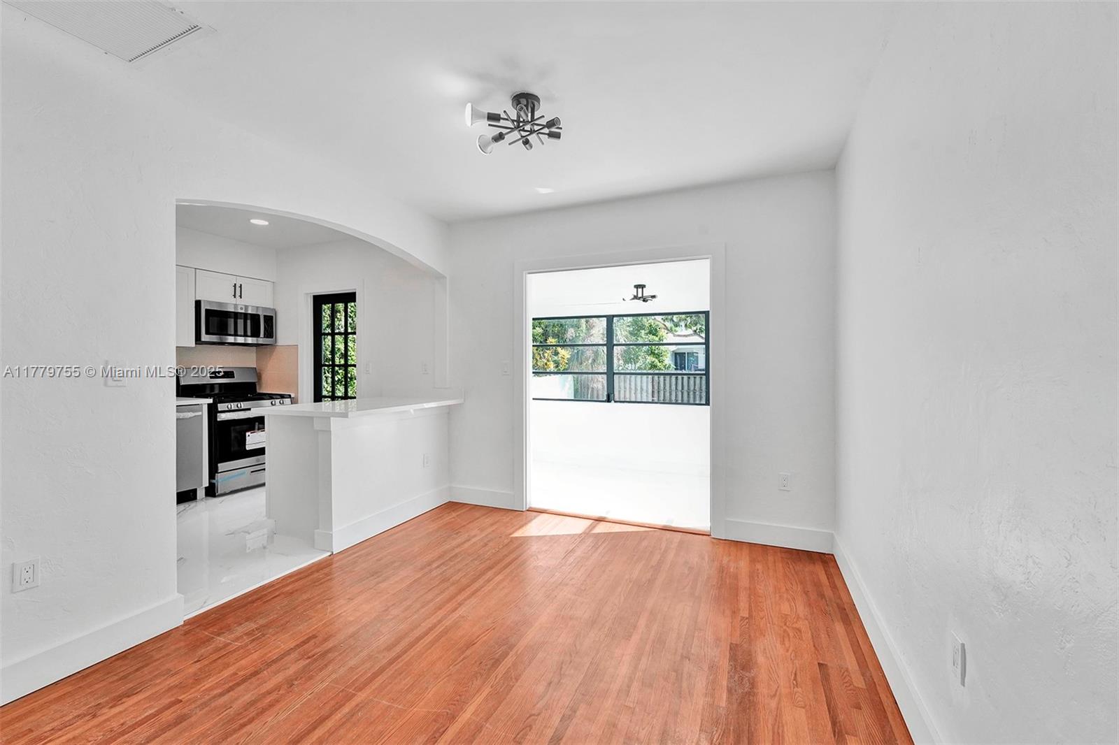 9173 Byron Avenue Surfside, FL 33154 - Photo 15 of 25 a view of a kitchen with wooden floor and a window