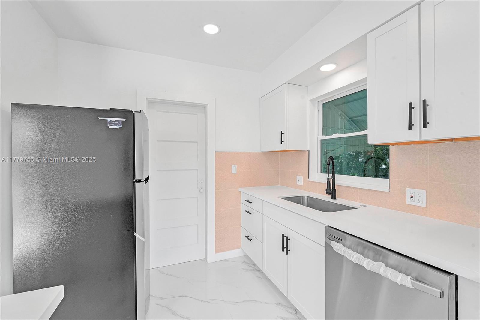 9173 Byron Avenue Surfside, FL 33154 - Photo 19 of 25 a kitchen with a sink and a refrigerator