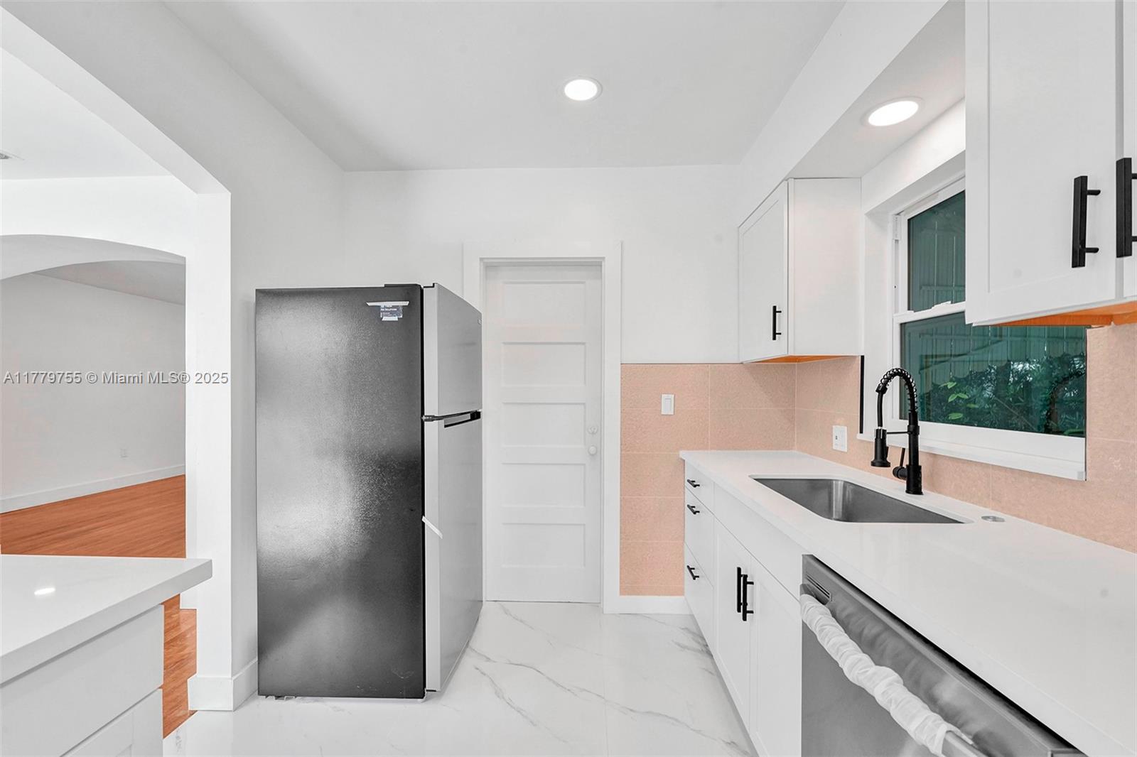 9173 Byron Avenue Surfside, FL 33154 - Photo 20 of 25 a kitchen with a refrigerator sink and cabinets
