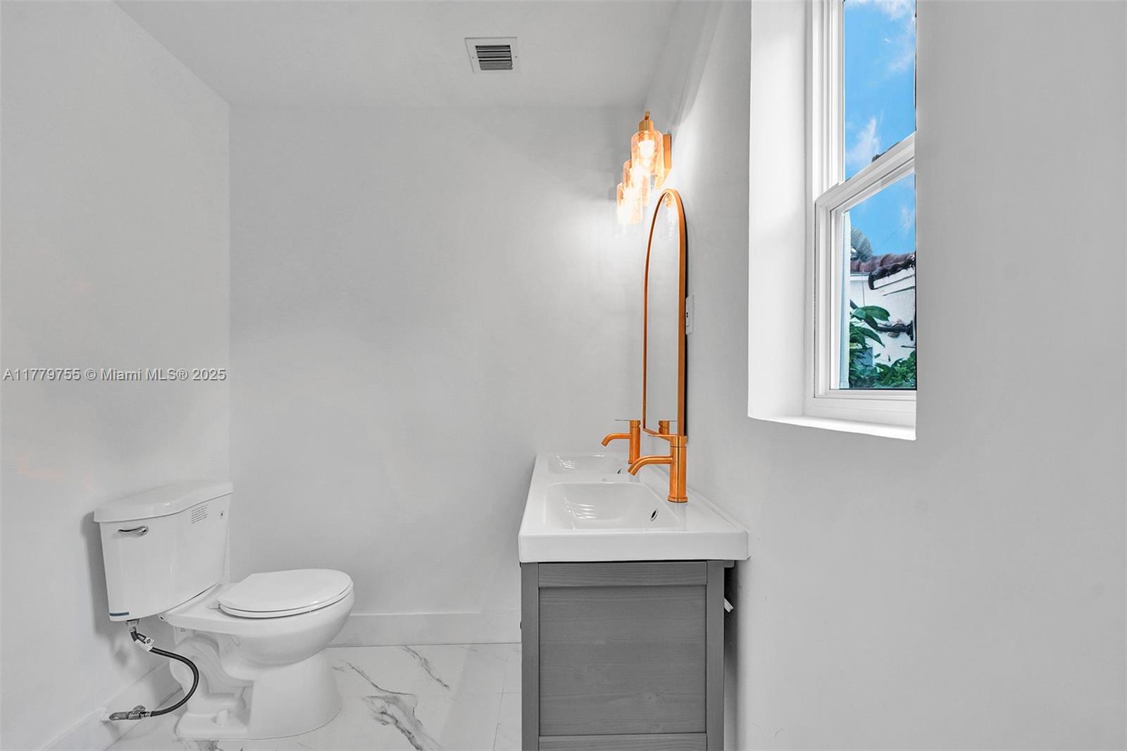 9173 Byron Avenue Surfside, FL 33154 - Photo 5 of 25 a bathroom with a toilet sink and mirror