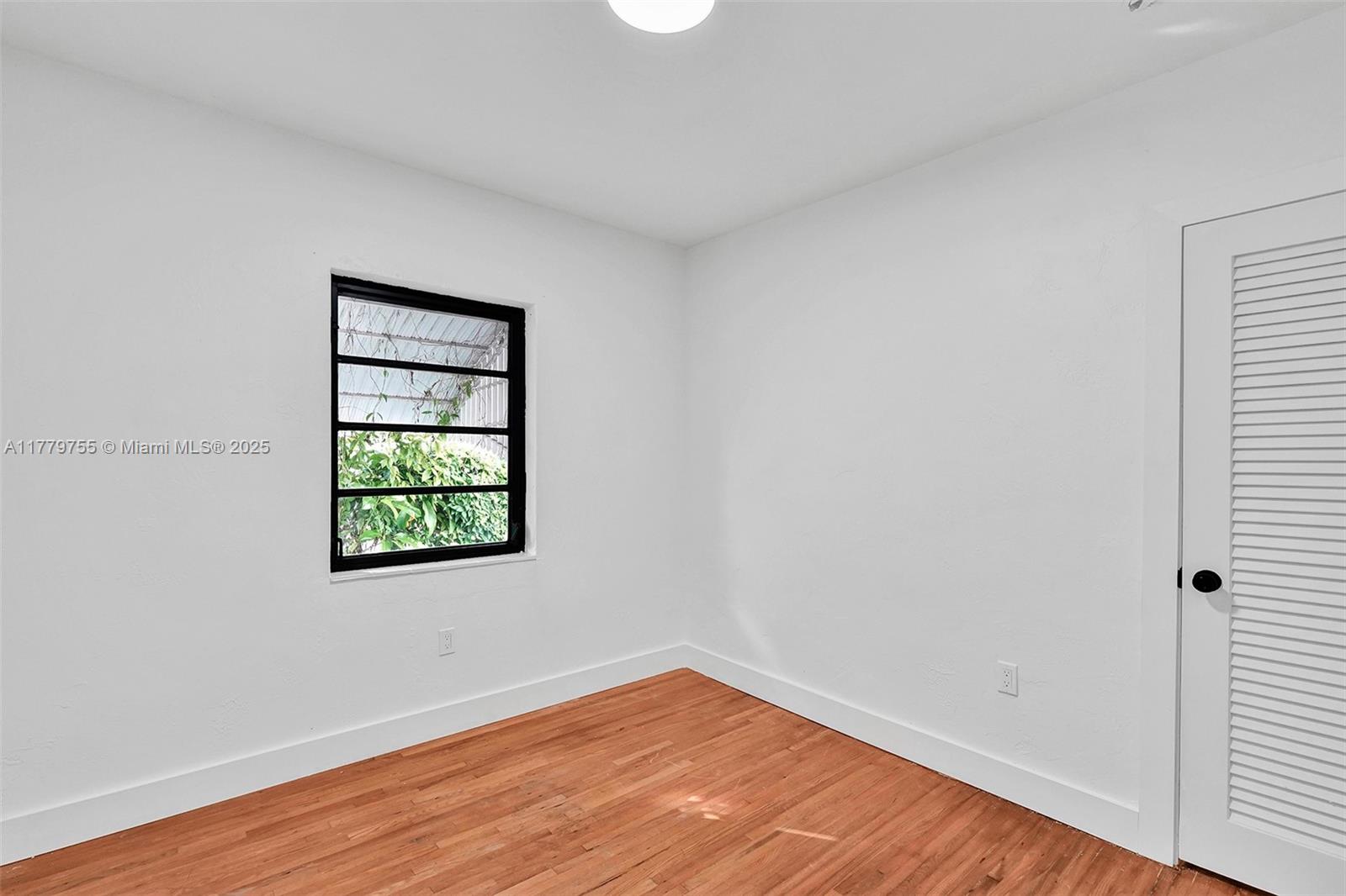 9173 Byron Avenue Surfside, FL 33154 - Photo 8 of 25 an empty room with wooden floor and windows