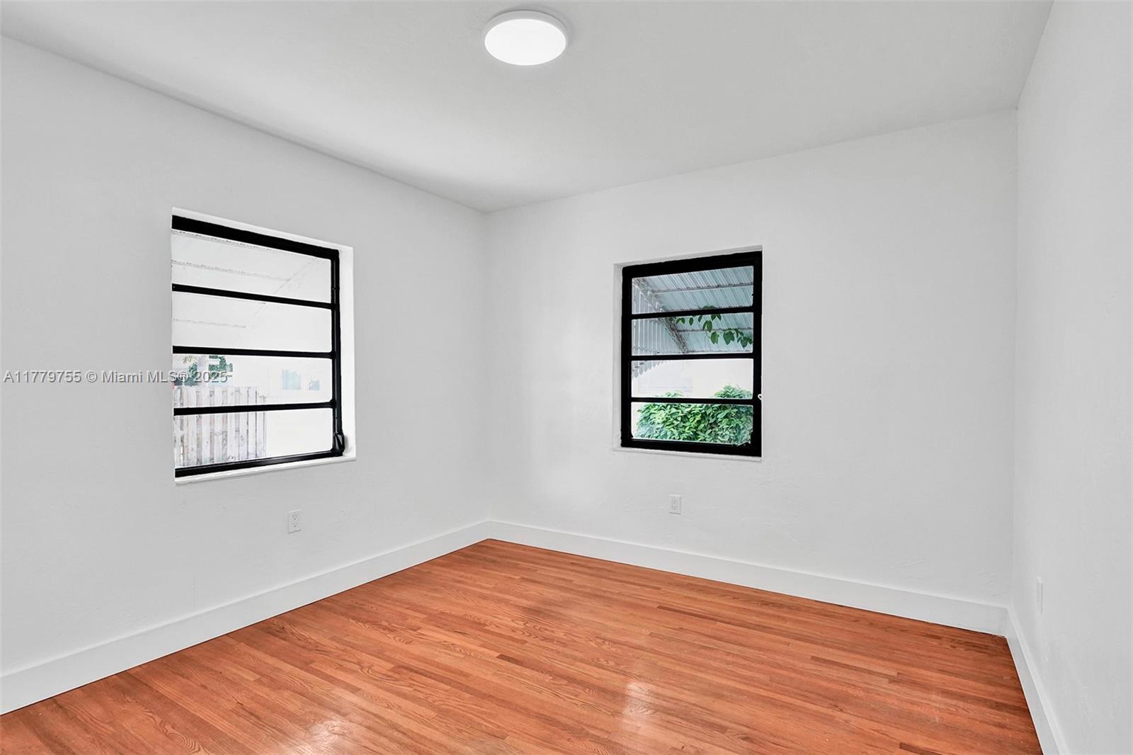 9173 Byron Avenue Surfside, FL 33154 - Photo 9 of 25 an empty room with a window and wooden floor