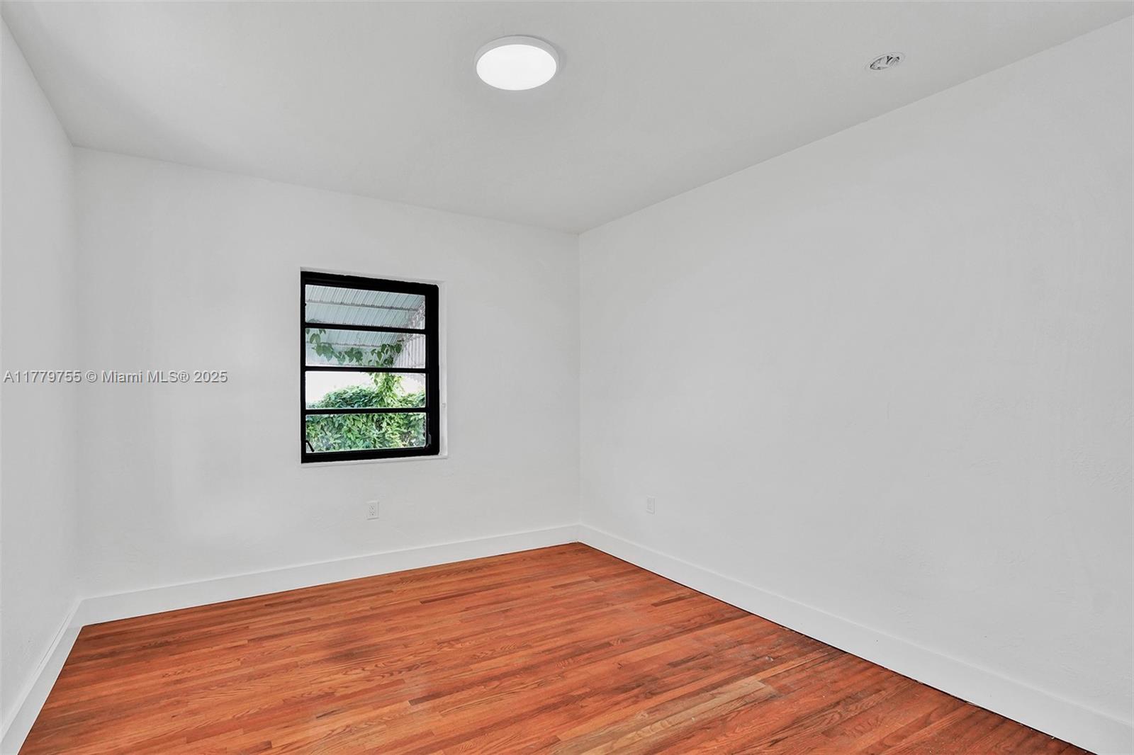 9173 Byron Avenue Surfside, FL 33154 - Photo 10 of 25 a view of an empty room with wooden floor and a window