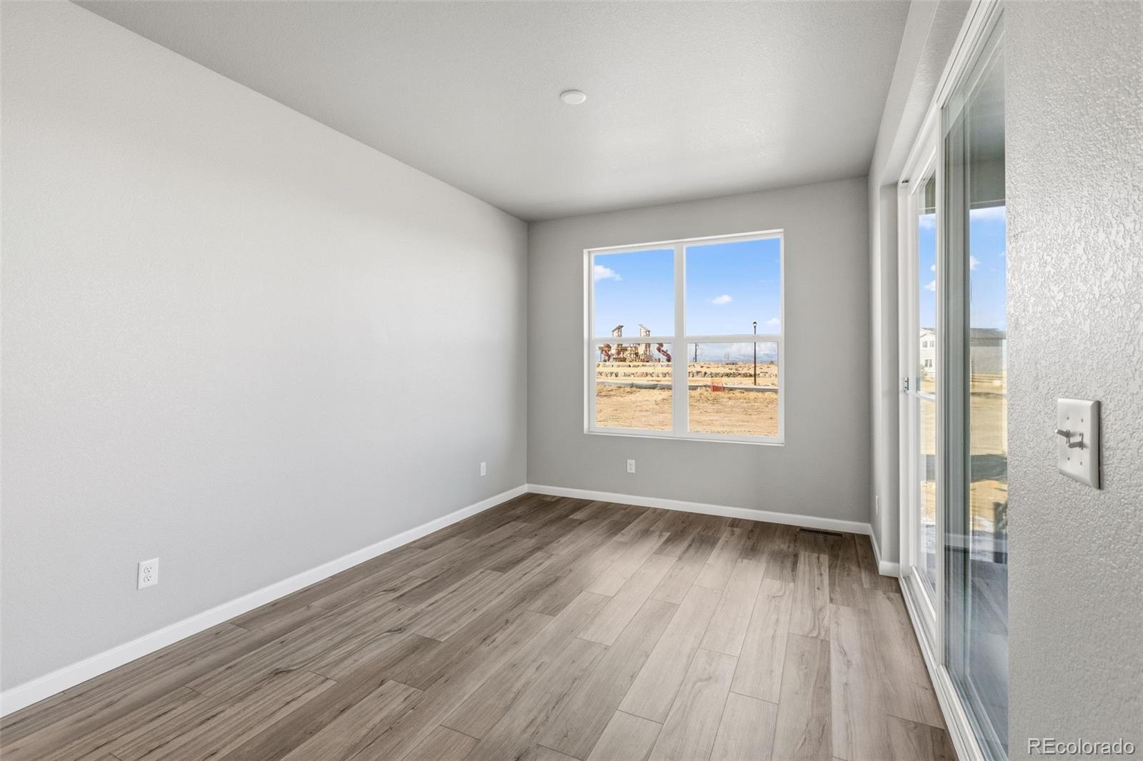 6801 Utica Court Firestone, CO 80504 - Photo 9 of 22 a view of an empty room with wooden floor and a window