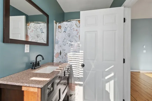 a bathroom with a granite countertop sink and a mirror