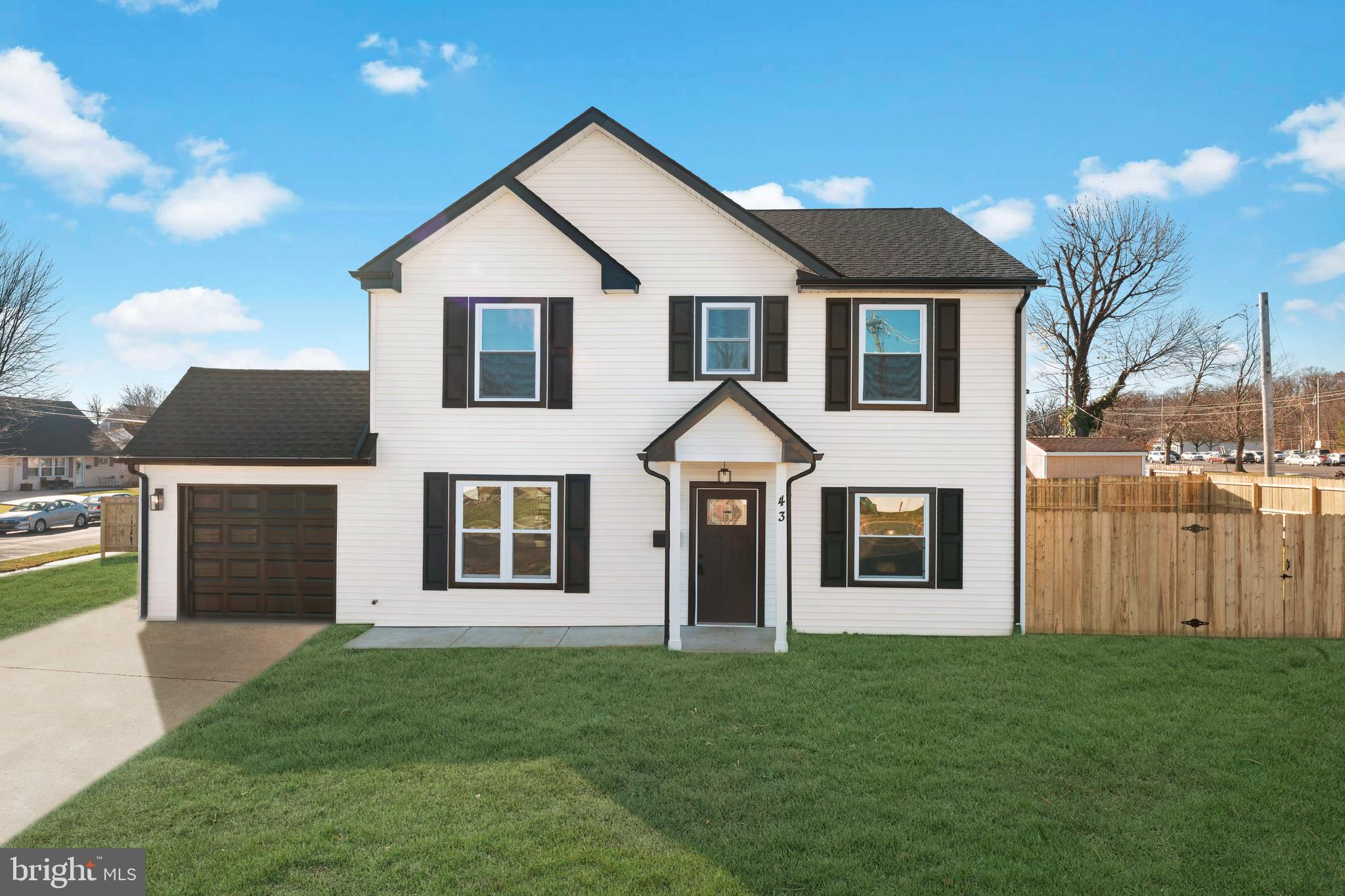 a view of a yard in front of a house with plants and large tree