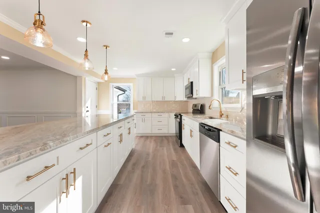 a large kitchen with stainless steel appliances lots of counter space and wooden floor
