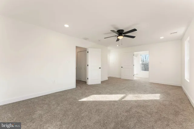 an empty room with fan and windows