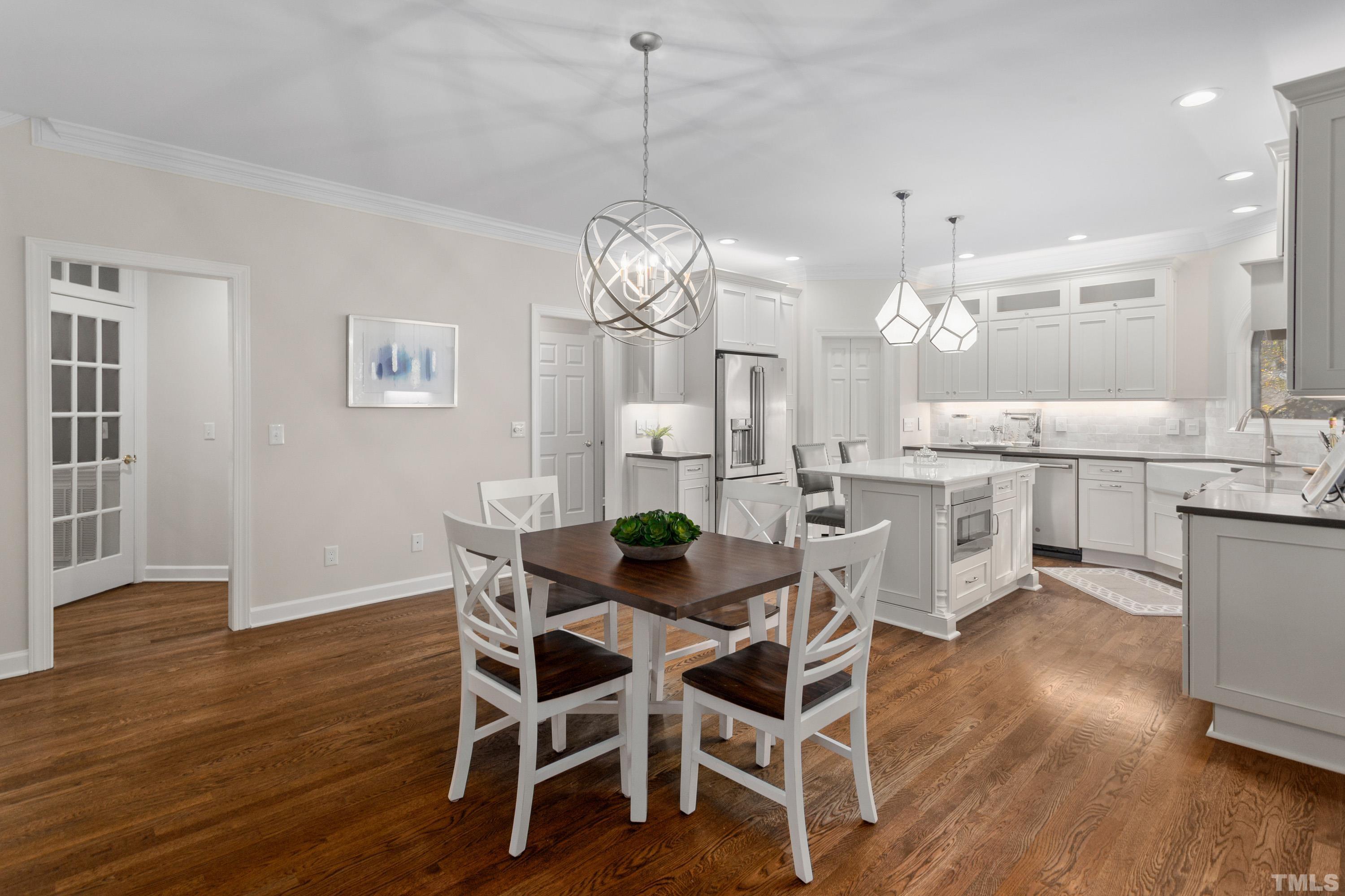 114 Old Pros Way Cary, NC 27513 - Photo 21 of 26 a dining room with wooden floor a chandelier a glass table and chairs