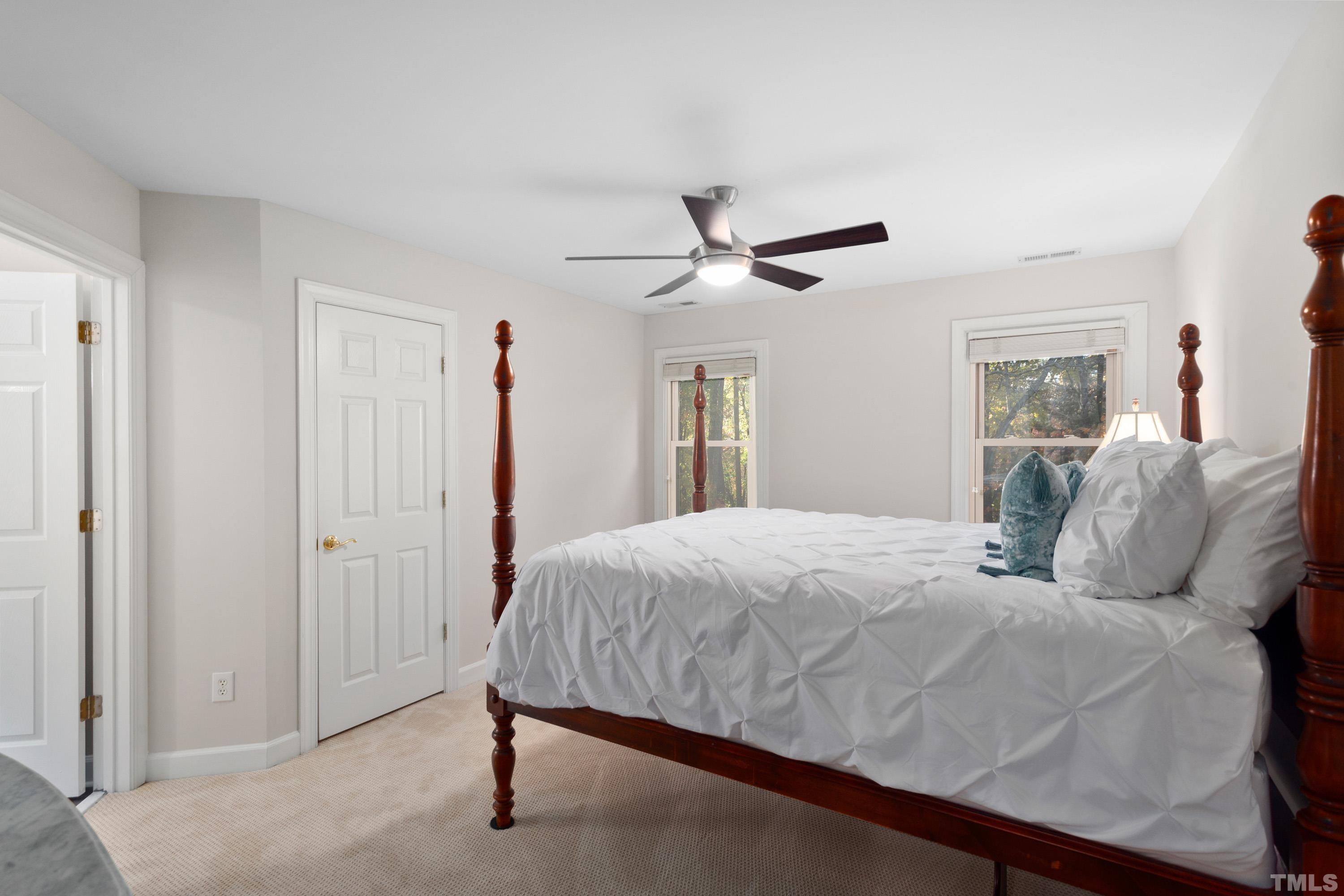 114 Old Pros Way Cary, NC 27513 - Photo 24 of 26 a bedroom with a large bed and a chandelier