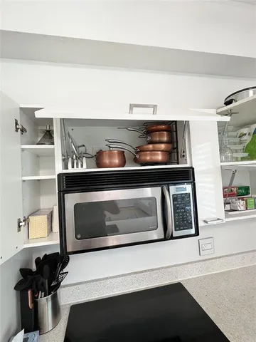 a living room with lots of clutter and cabinets