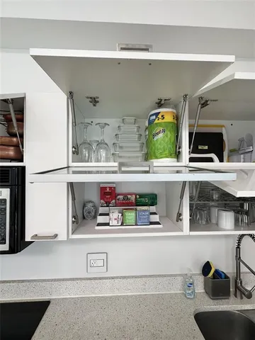 a kitchen with a sink and a stove with wooden floor