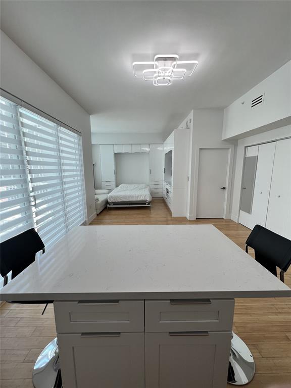 133 Northeast 2nd Avenue, Unit 1610 Miami, FL 33132 - Photo 3 of 52 a bedroom with a bed and a chandelier