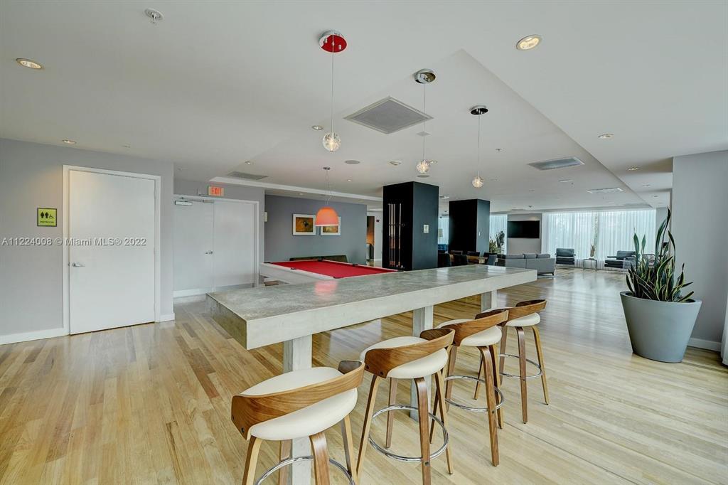 133 Northeast 2nd Avenue, Unit 1610 Miami, FL 33132 - Photo 46 of 52 a room with stainless steel appliances kitchen island a table and chairs in it