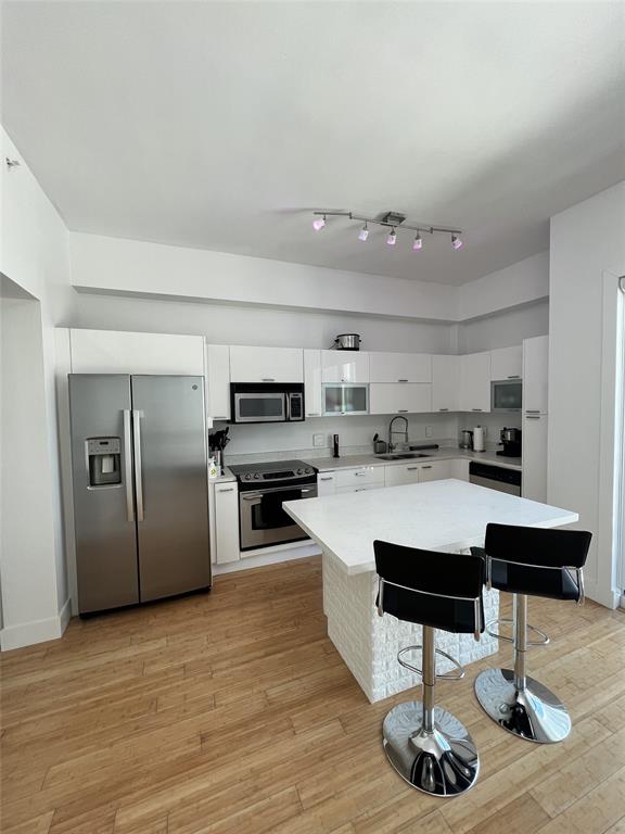 133 Northeast 2nd Avenue, Unit 1610 Miami, FL 33132 - Photo 9 of 52 a living room with stainless steel appliances kitchen island granite countertop furniture a rug a kitchen counter and a sink