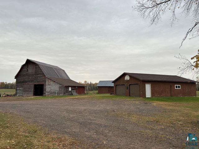 8353 Mannik Road Iron River, WI 54847 - Photo 13 of 52 View of yard featuring an outdoor structure, a barn, and a garage
