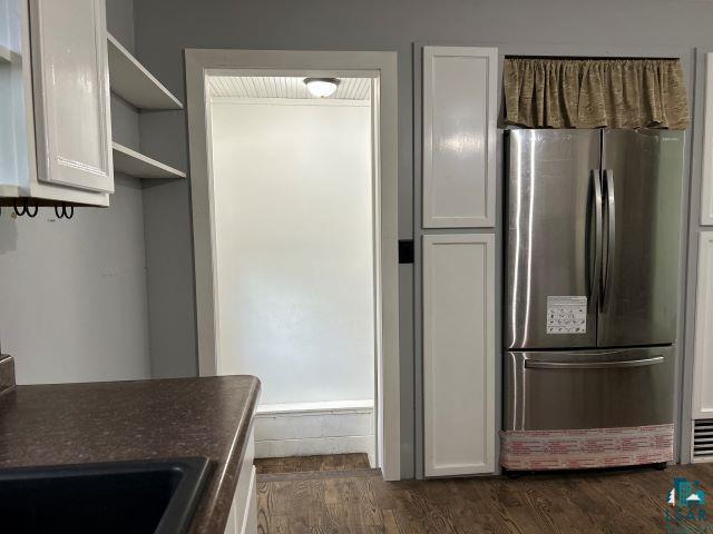 8353 Mannik Road Iron River, WI 54847 - Photo 31 of 52 Kitchen featuring freestanding refrigerator, open shelves, dark wood-type flooring, white cabinets, and dark countertops