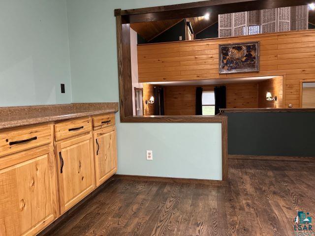 8353 Mannik Road Iron River, WI 54847 - Photo 34 of 52 Kitchen featuring dark wood-type flooring, light brown cabinetry, and wood walls