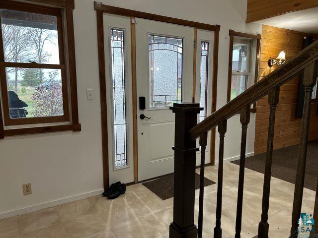 8353 Mannik Road Iron River, WI 54847 - Photo 37 of 52 Entrance foyer with healthy amount of natural light, stairs, beamed ceiling, and wooden walls
