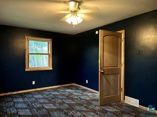 8353 Mannik Road Iron River, WI 54847 - Photo 48 of 52 Empty room with dark colored carpet and ceiling fan