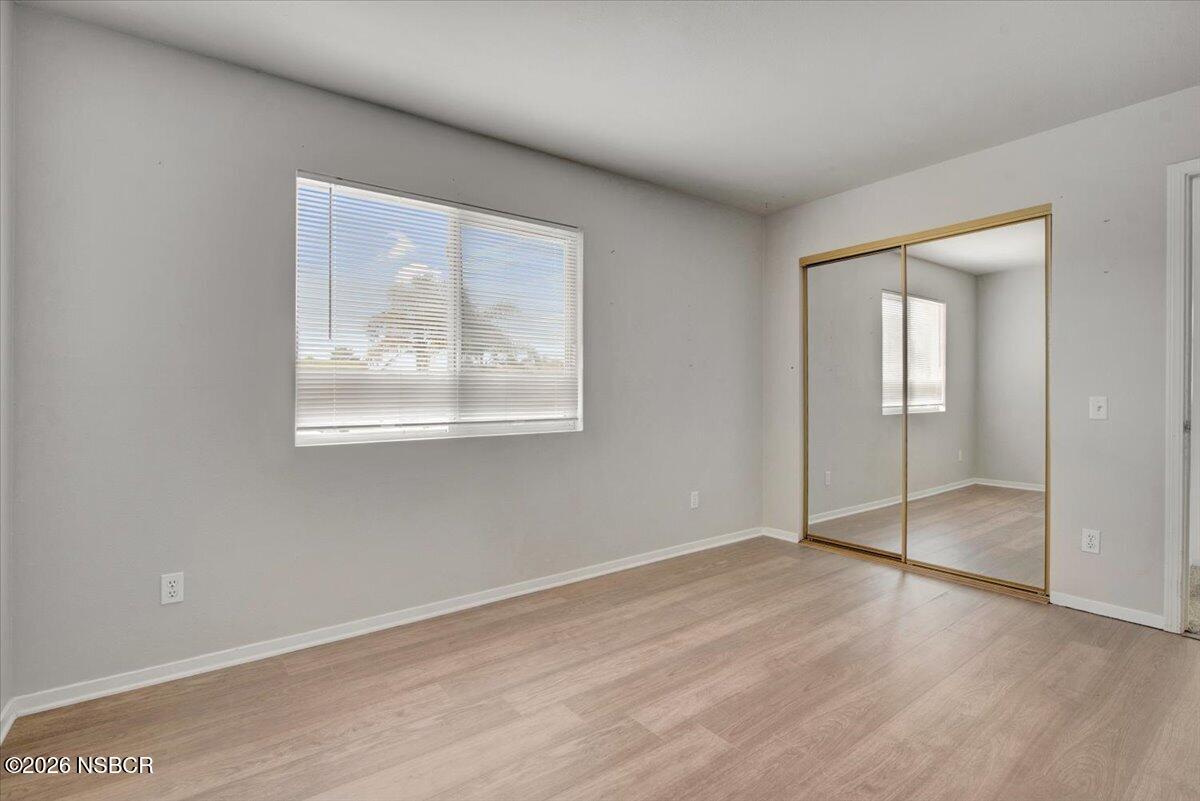 1248 Stonebrook Drive Lompoc, CA 93436 - Photo 26 of 38 an empty room with wooden floor and mirror