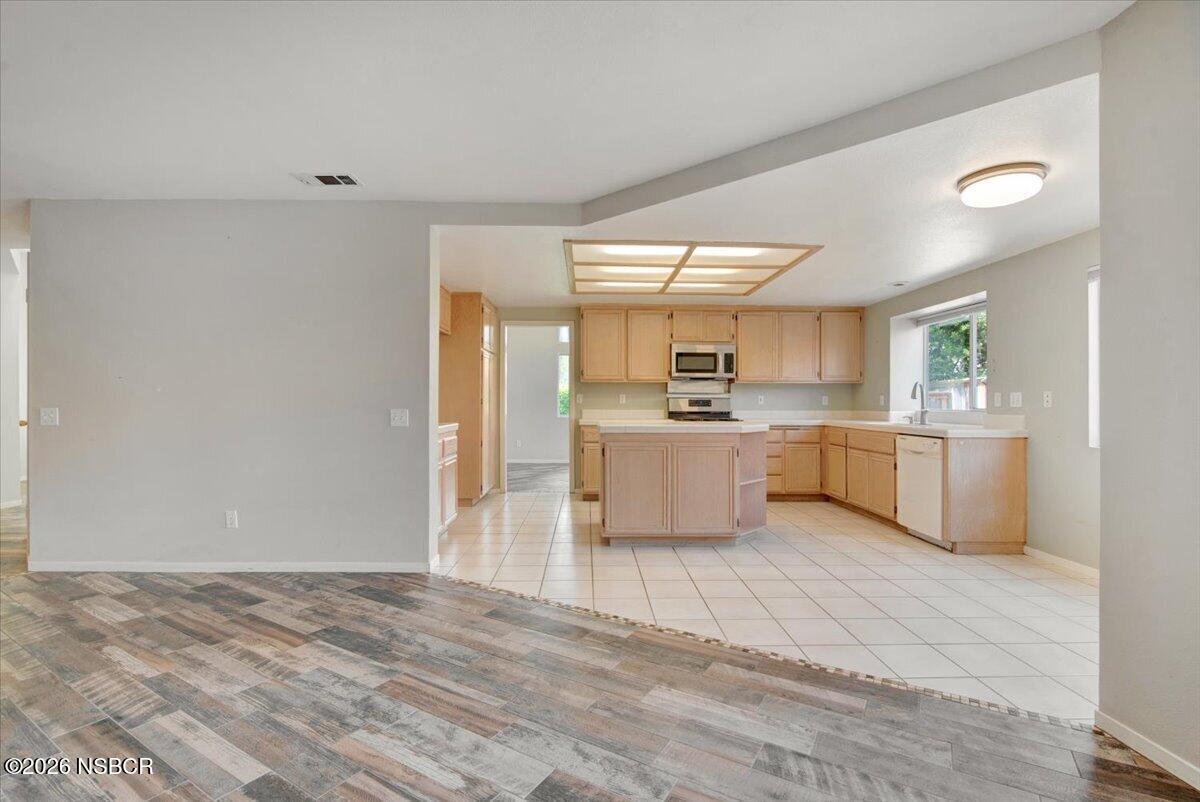 1248 Stonebrook Drive Lompoc, CA 93436 - Photo 8 of 38 a large white kitchen with a stove a sink dishwasher and a refrigerator with wooden floor