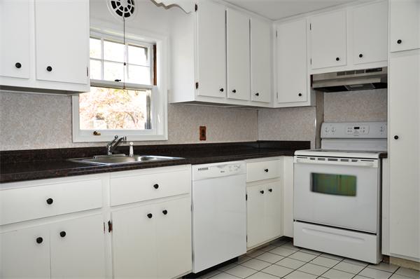 36 Coolidge Road Milton, MA 02186 - Photo 5 of 12 a kitchen with granite countertop white cabinets and white appliances