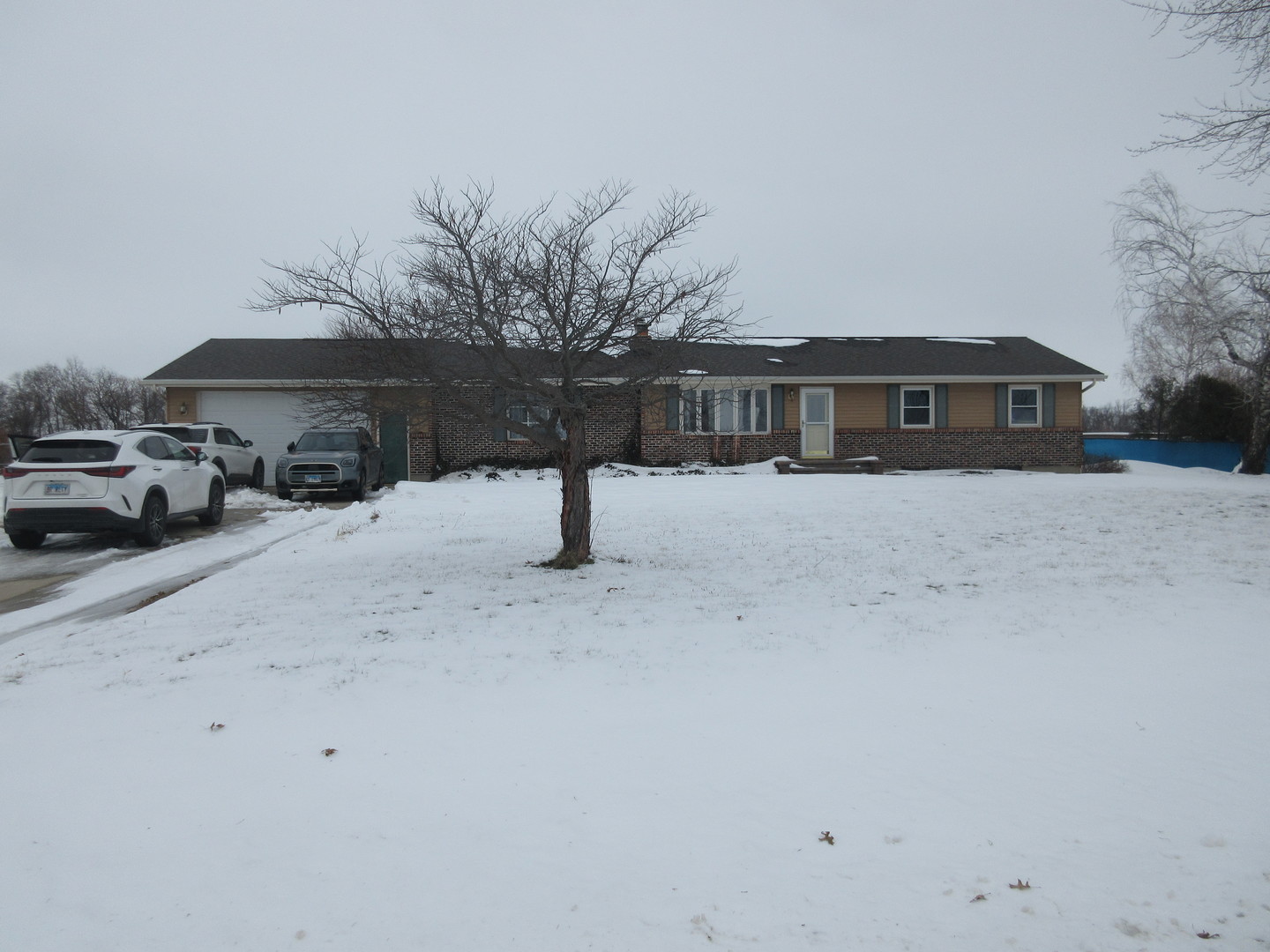 a front view of a house with a yard covered in snow