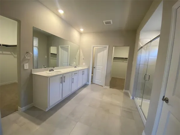 a bathroom with a double vanity sink and mirror with shower