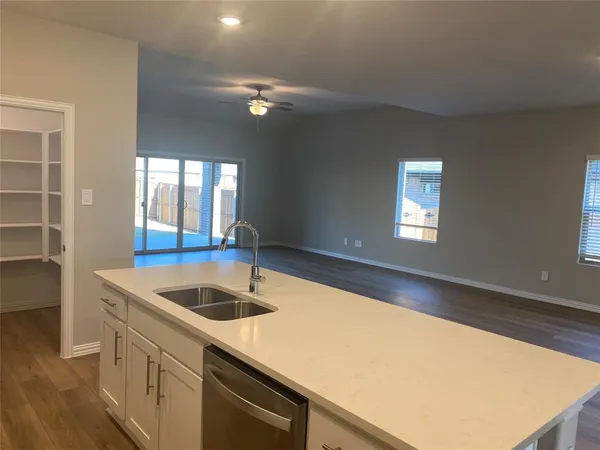 a kitchen with a sink a counter space and a view of living room
