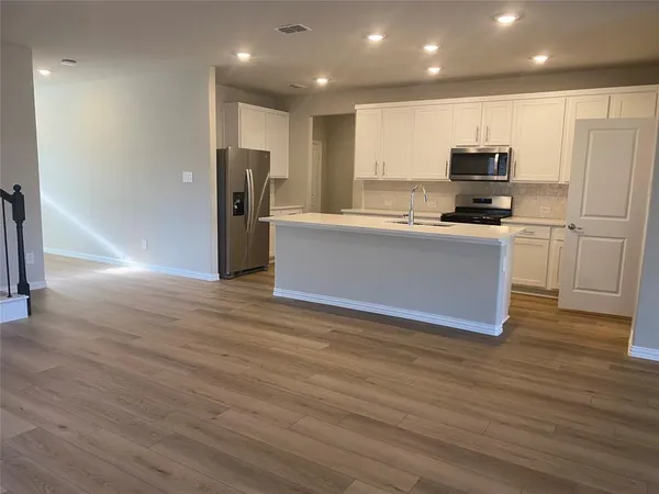 a kitchen with stainless steel appliances granite countertop a refrigerator and a stove