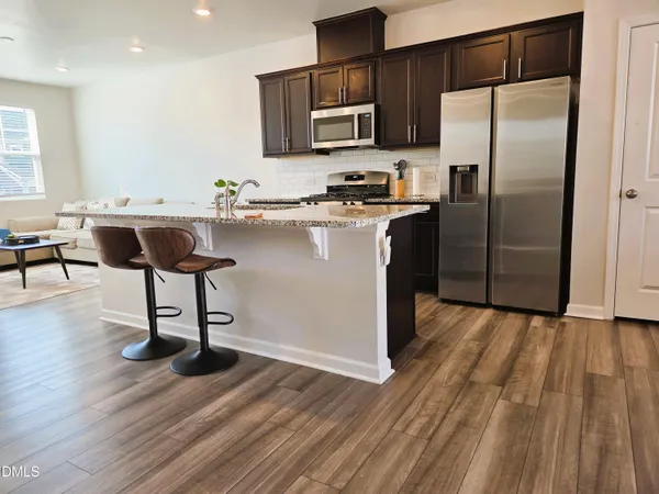 a kitchen with stainless steel appliances granite countertop a stove a sink and a microwave