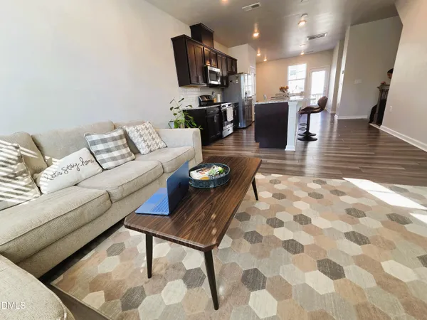 a kitchen with stainless steel appliances kitchen island granite countertop a refrigerator a stove top oven a sink and cabinets