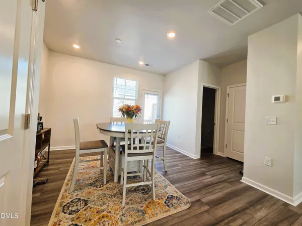 a view of a hallway with wooden floor and a bathroom