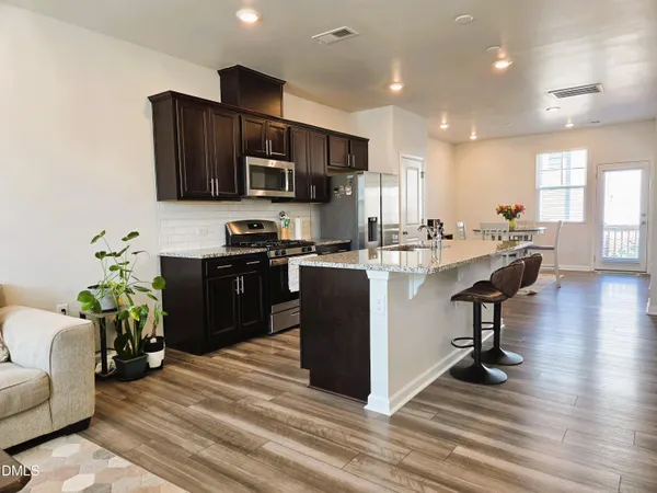 a kitchen with stainless steel appliances granite countertop a stove a sink and a refrigerator