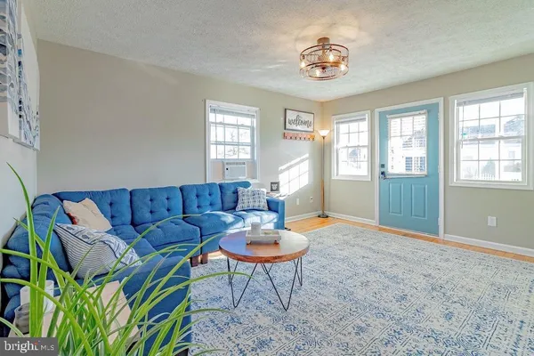 a living room with furniture a window and a chandelier
