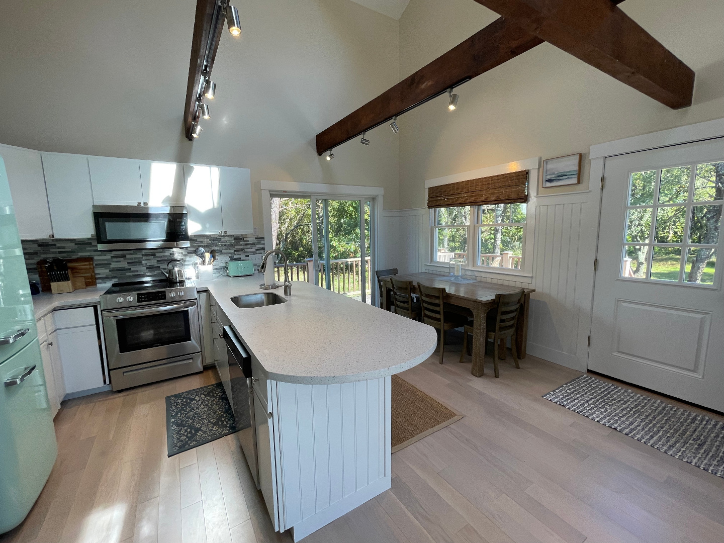 300 Chappaquiddick Road Edgartown, MA 02539 - Photo 6 of 16 a kitchen with kitchen island a stove a sink a dining table and chairs with wooden floor