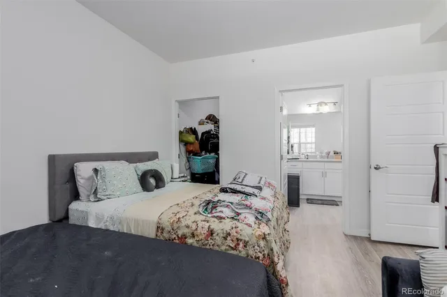 a bedroom with a bed and a view of kitchen