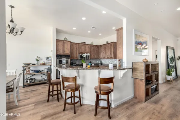a kitchen with stainless steel appliances kitchen island granite countertop a refrigerator and cabinets
