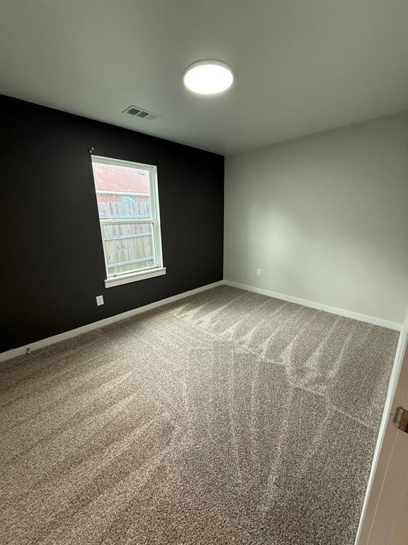 505 Thomas Street Terrell, TX 75160 - Photo 30 of 38 Neutral-toned carpeted flooring with a contrasting dark accent wall