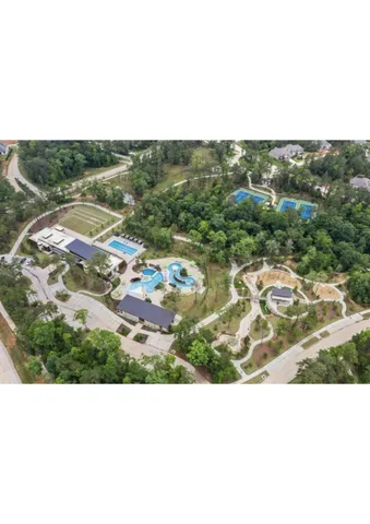 a view of swimming pool with a yard and a large tree