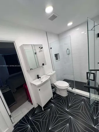 a bathroom with a toilet a sink and mirror