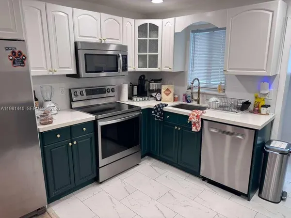 a kitchen with stainless steel appliances granite countertop a sink stove and microwave