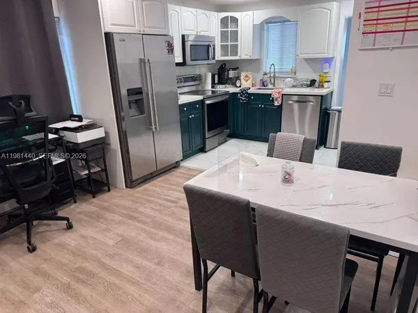 a kitchen with a refrigerator a stove and a dining table