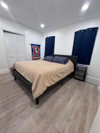 a spacious bedroom with a bed and a dresser